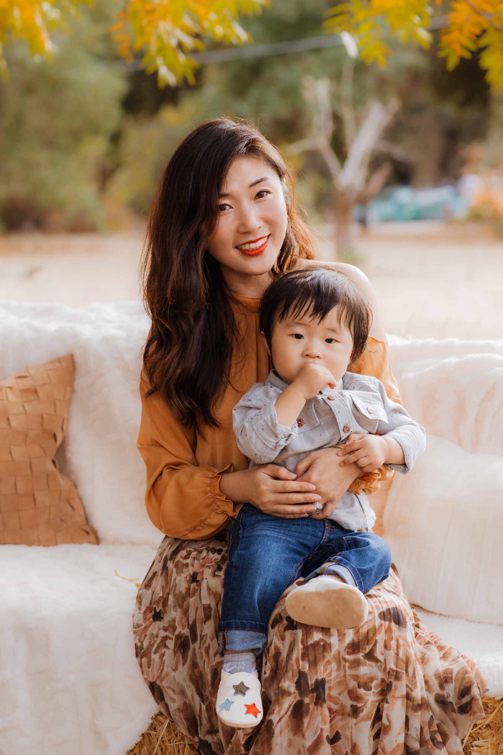 A woman holding a child on top of a couch.