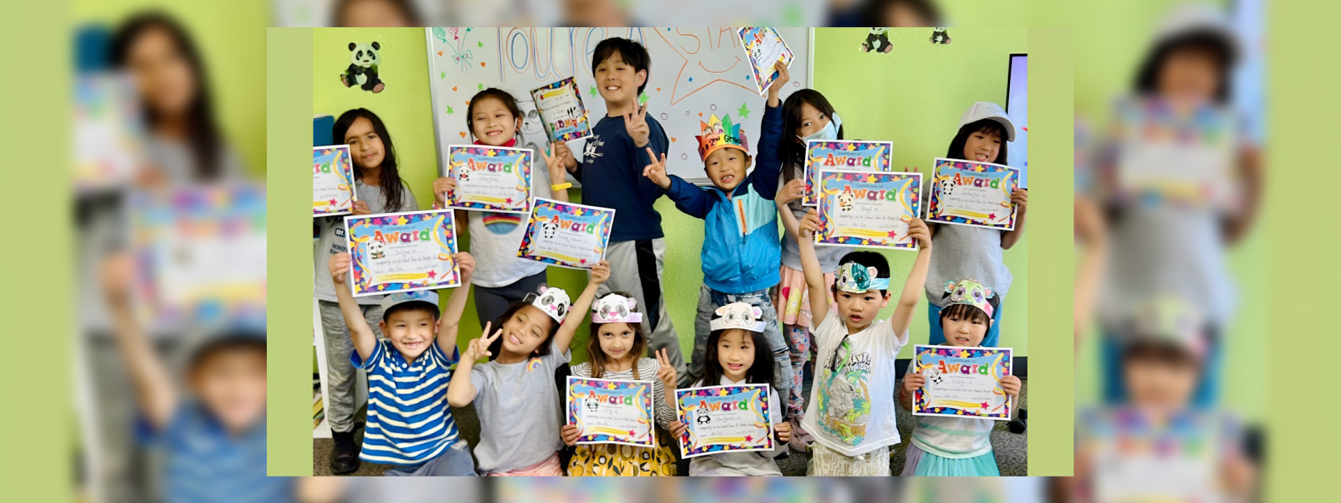 Children smiling and holding certificates in a classroom setting.