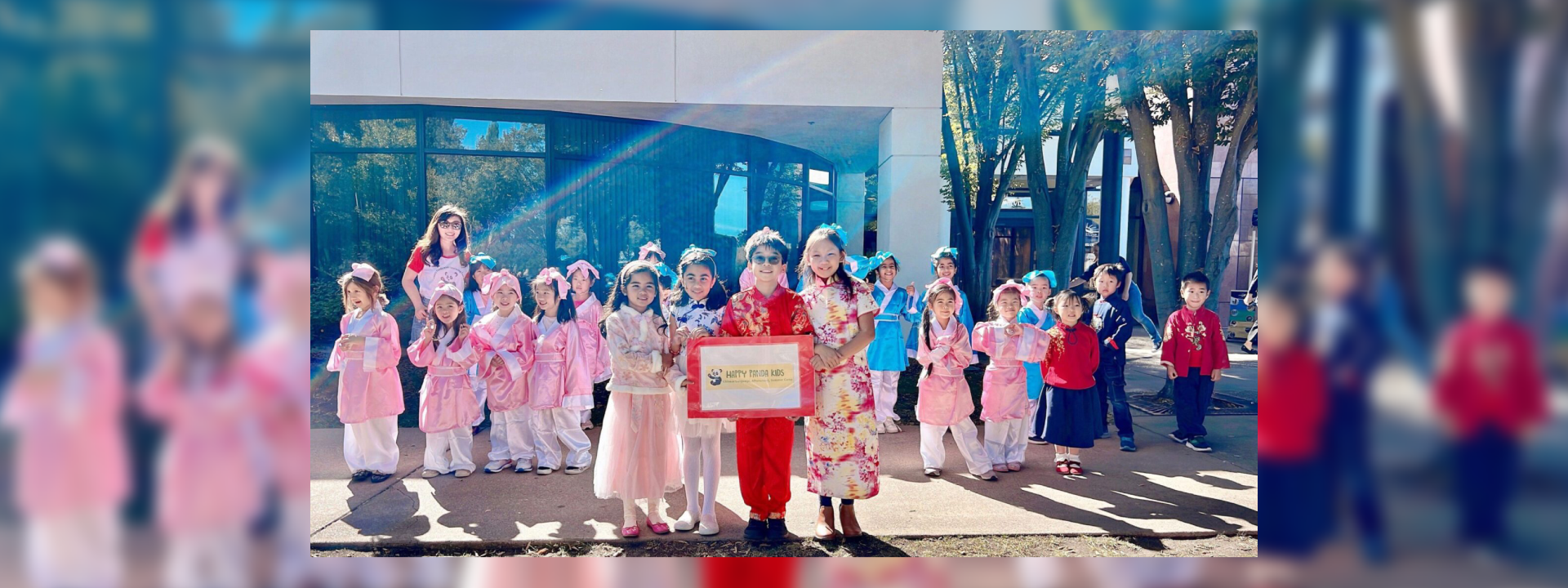 Children dressed in traditional attire pose with a teacher holding a certificate.
